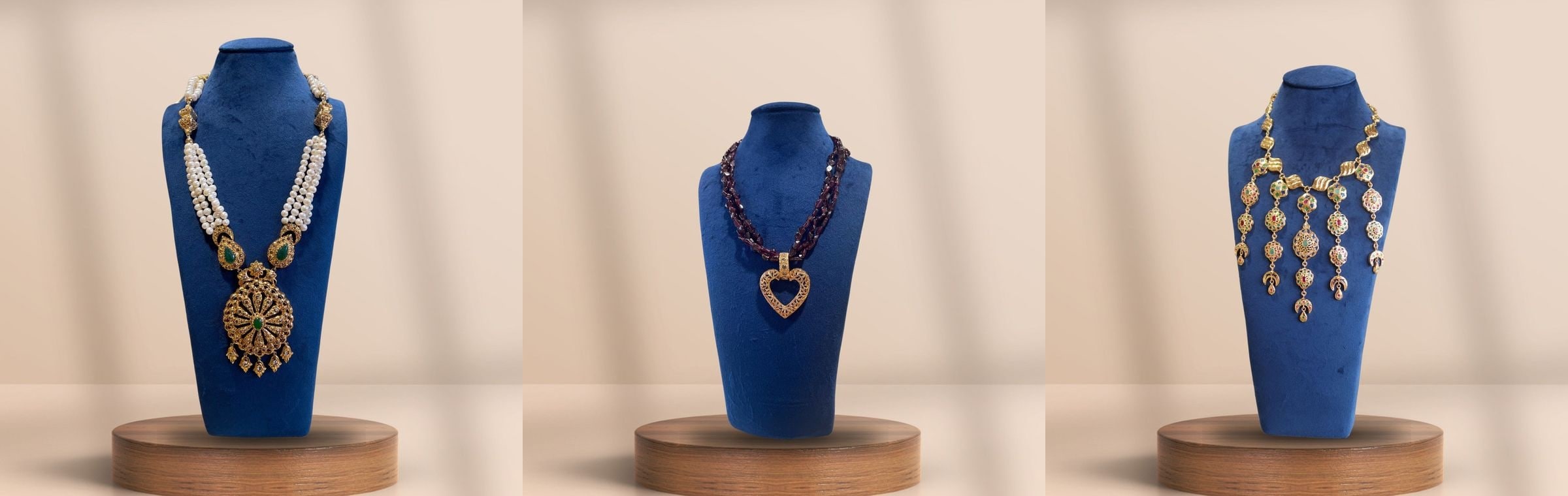 Three Moroccan necklaces in gold and pearl, shown on blue velvet busts